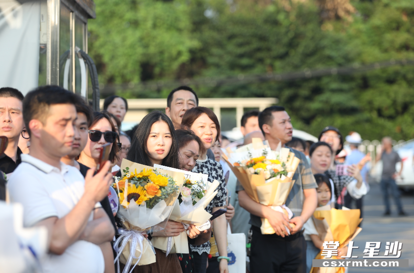 家长抱着花束等待考生走出考点。