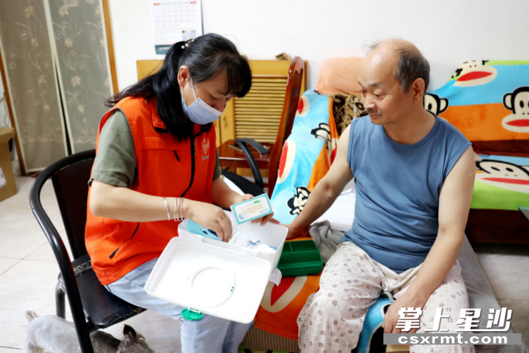 图为工作人员为孙建辉老人配备了应急救护包。 盛磊 摄