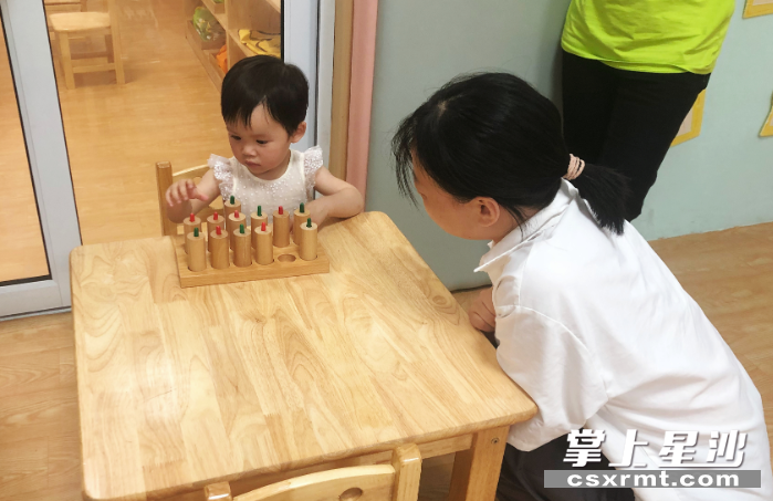陈女士家的宝宝在尝试压觉筒，锻炼手部力量。受访者供图