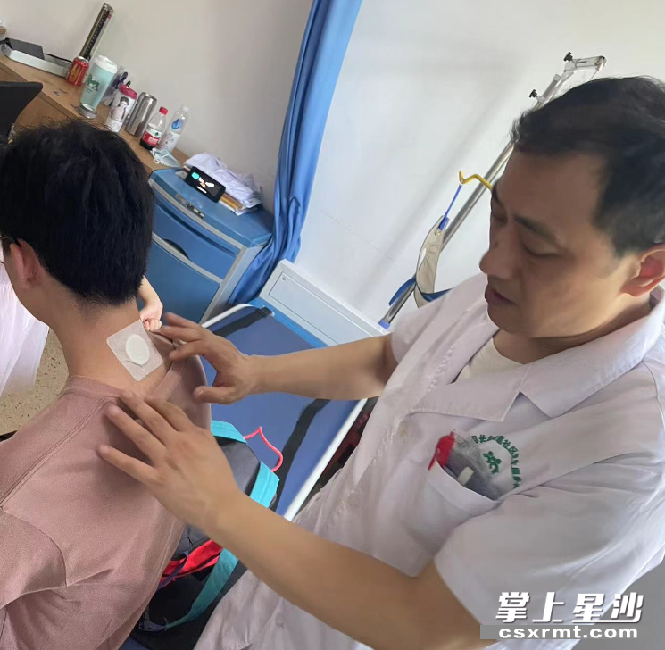 图为医生正在贴三伏贴。