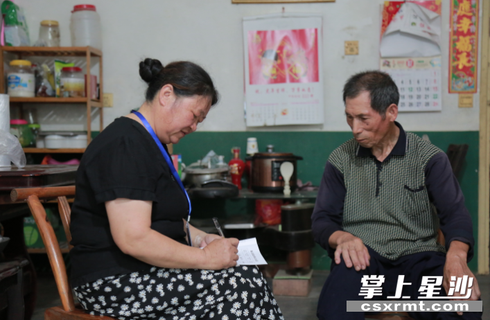 长沙县黄兴镇干杉社区居民代表陈荣上门为行动不便老人登记养老业务。