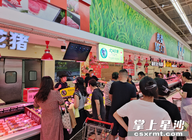 图为多位居民在大围子猪肉销售摊点前挑选猪肉。县农业农村局供图