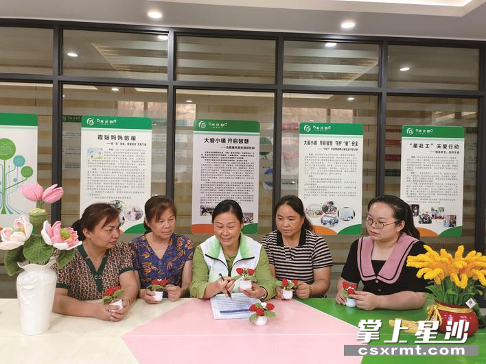 李柳英（中）带领当地妇女编织毛线花，带动就业，提高生活幸福指数。 张庆 摄