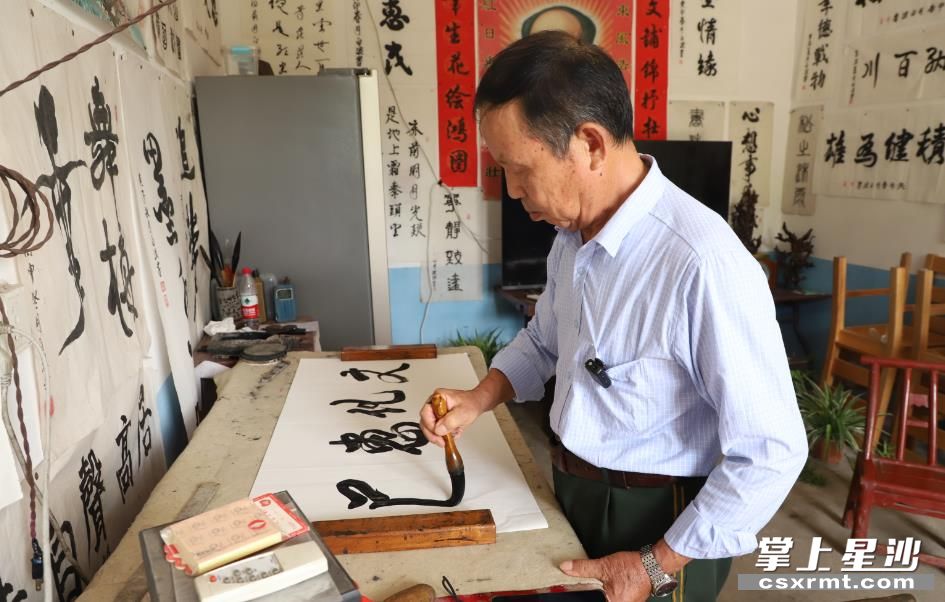 周建辉和他的书画作品。刘红艳 摄