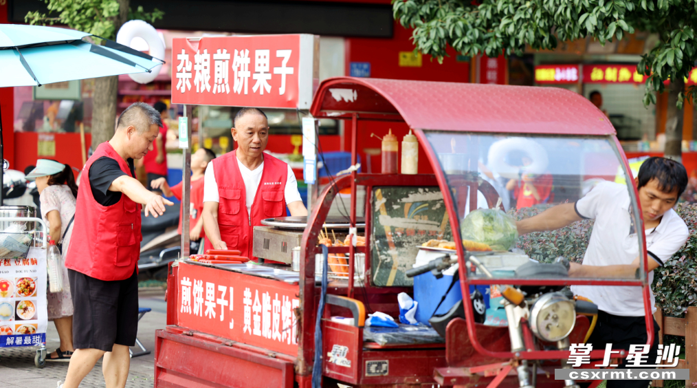 泉塘街道居民邓爹带领的海德星锋志愿服务队巡查发现小区前有摊贩违规占道摆摊，立即上前劝离。