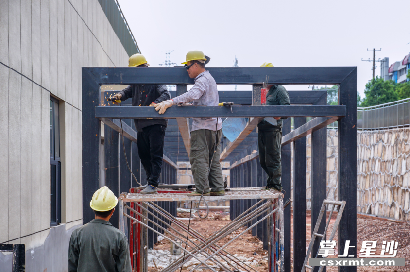 施工组正在搭建户外挡雨棚。 刘思源 摄