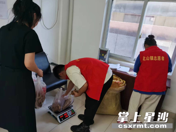 志愿者在帮忙销售农特产品。北山镇供图