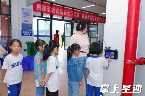 学生在老师的指引下刷脸支付餐费。