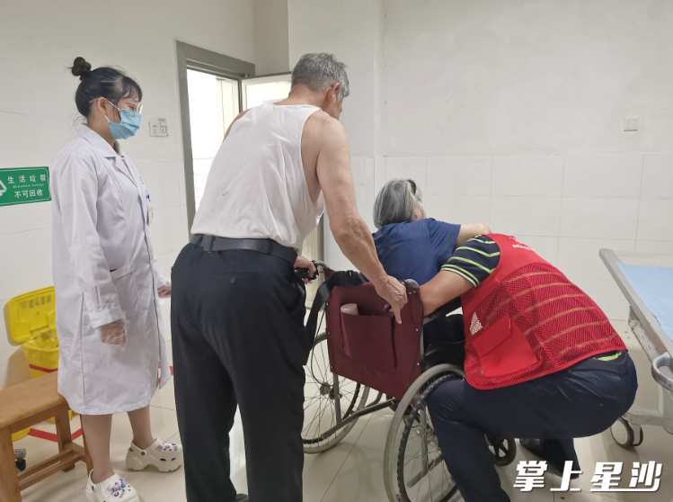 图为社工全程陪同范阿姨在长沙市第一医院做残疾人复评体检。