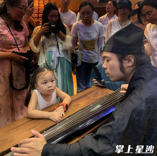 观众凑近古琴演奏家听琴。田园 摄