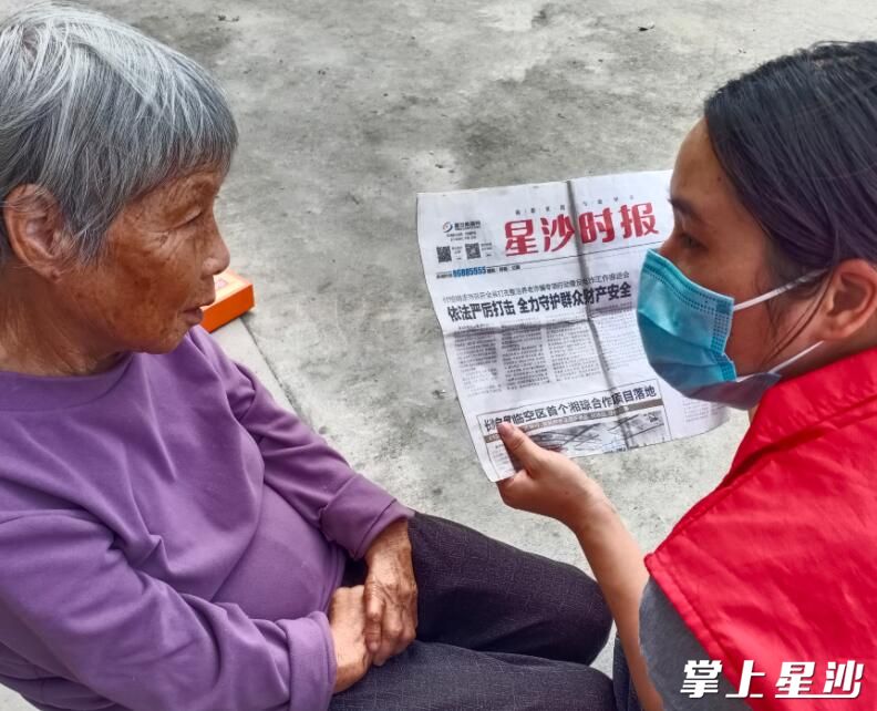 护工在老人家中为老人读报，陪伴老人。
