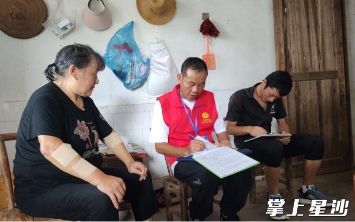 工作人员在朱翁伟（左）家中为其解释适老化改造的用途。