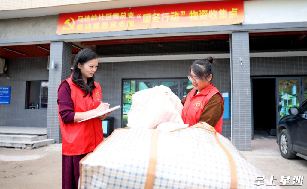 图为马达岭社区工作人员正在清点长沙县六中捐赠的首批爱心衣物。 盛磊 摄