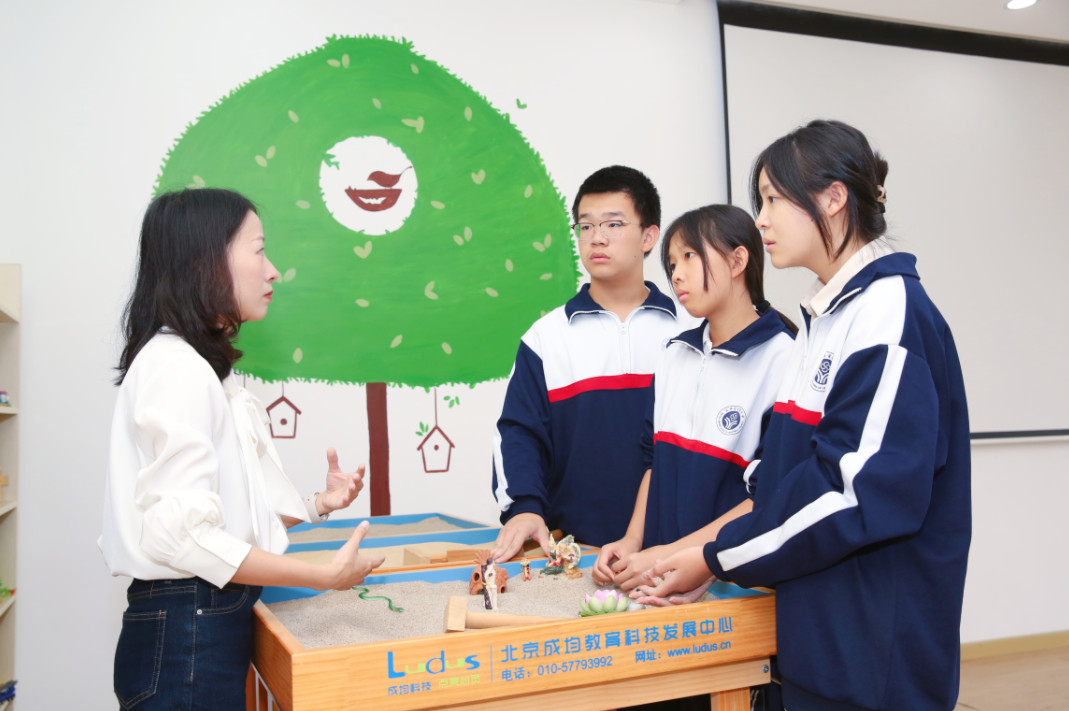 长沙县实验中学心理辅导专业老师余畅带着学生一起玩沙盘游戏。