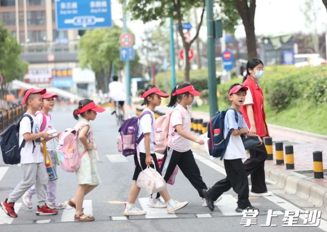 松雅湖二小学生过马路时自觉排队走斑马线。