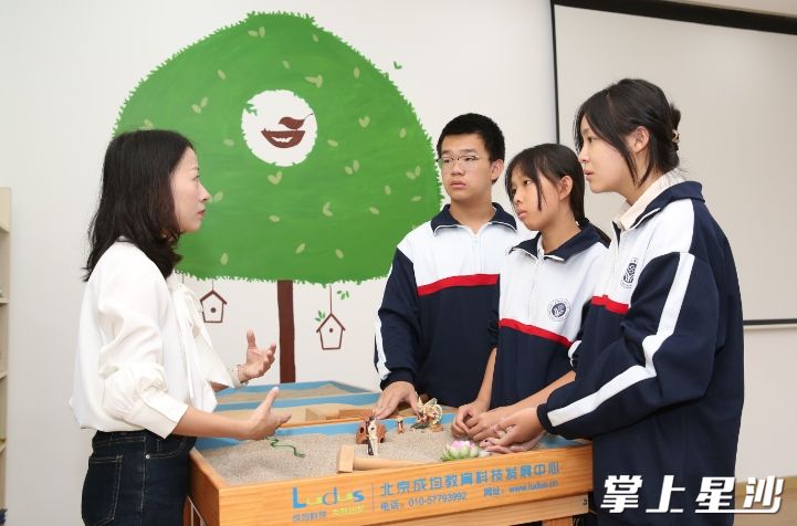 长沙县实验中学心理辅导专业老师余畅带着学生一起玩沙盘游戏。