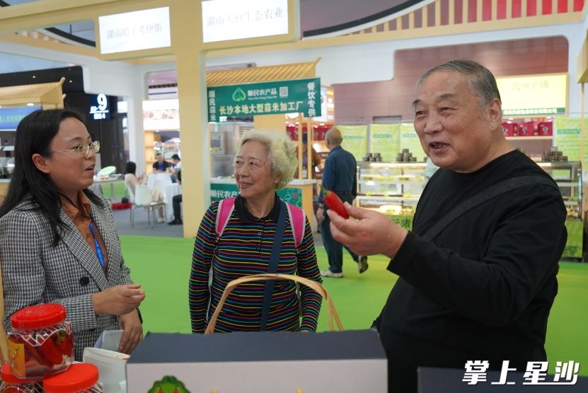 图为参展观众在展台购买光皮辣椒。邬振 摄
