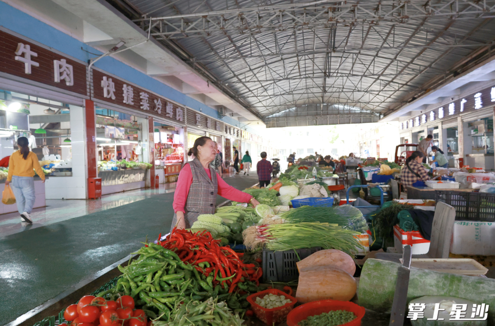 改造后的农贸市场内架设了100米不锈钢摊位台，流动摊贩可以把菜摆台上卖。均为文雅丽 摄