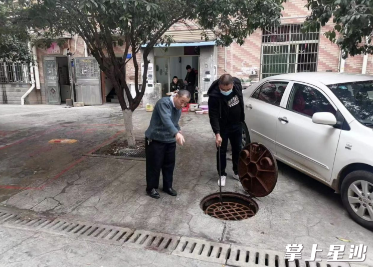 李存正在为社区居民排查下水道堵塞问题。社区供图