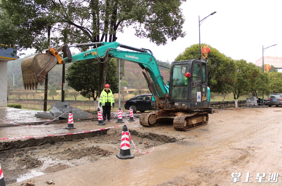 在振兴南路维修改造工程施工建设现场，施工人员正在用挖机将破损的路板挖掉。