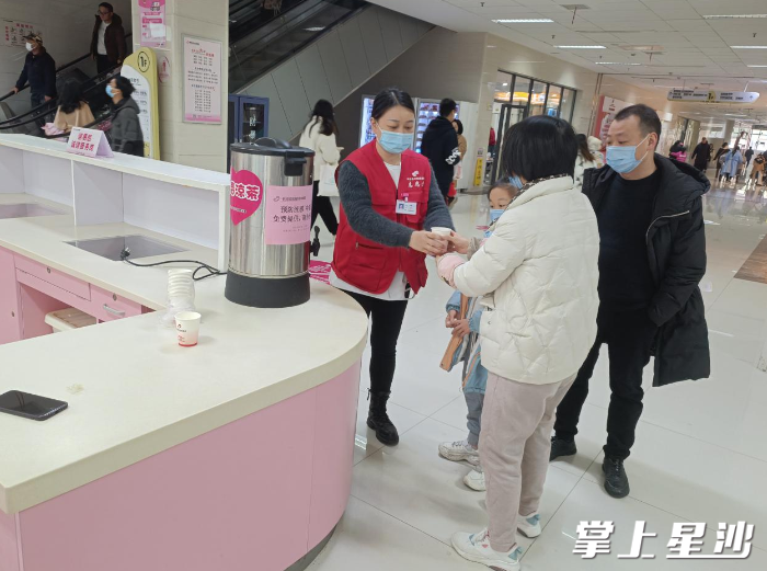 在医院门诊大厅，医疗卫生志愿者为市民发放预防流感中药汤剂。医院供图