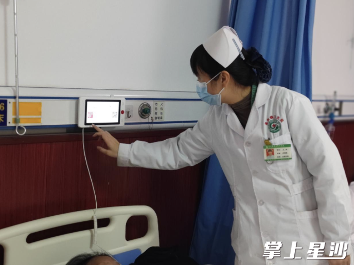 护士通过智能床头屏查看病人住院信息。