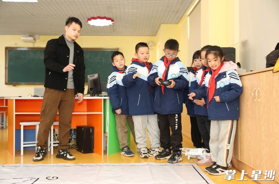 学生在老师指导下学习操控无人机。