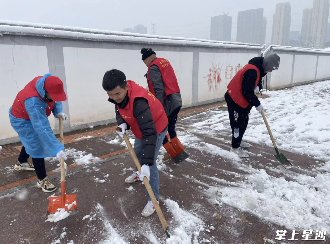 图为县住建局开展志愿扫雪除冰活动。