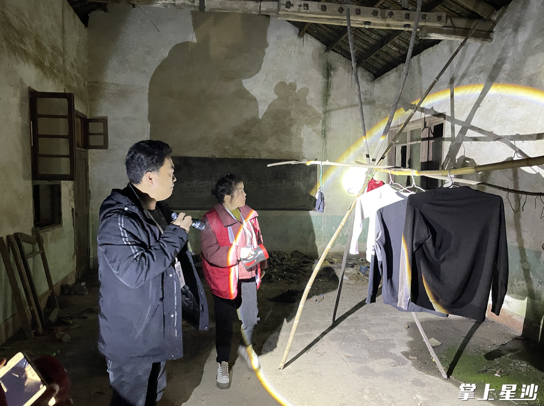 救助站工作人员在废弃房屋内搜寻。张梓峰 摄