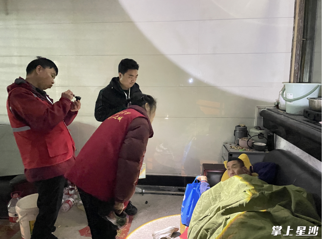 救助站工作人员给流浪人员送物资,并询问生活状况。张梓峰 摄