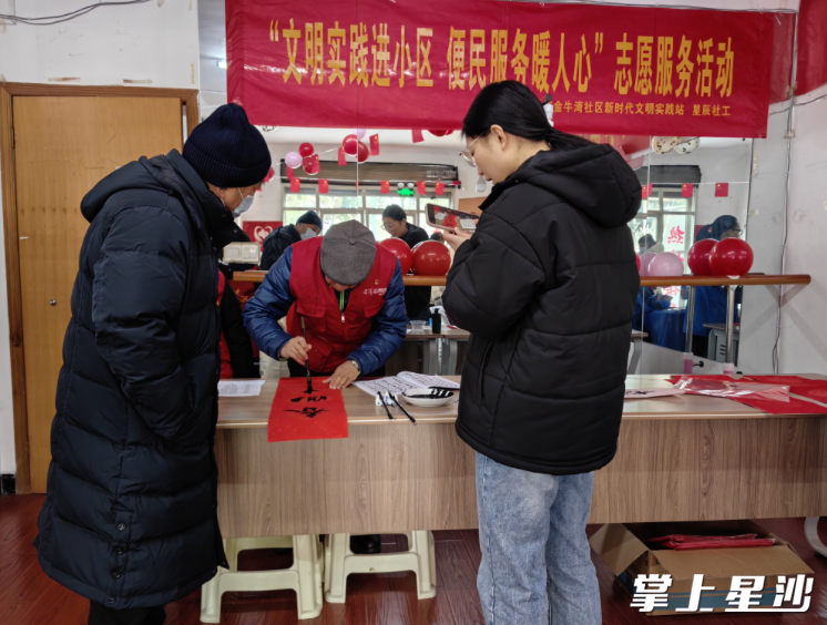 图为书法爱好者挥毫泼墨，为居民书写春联。