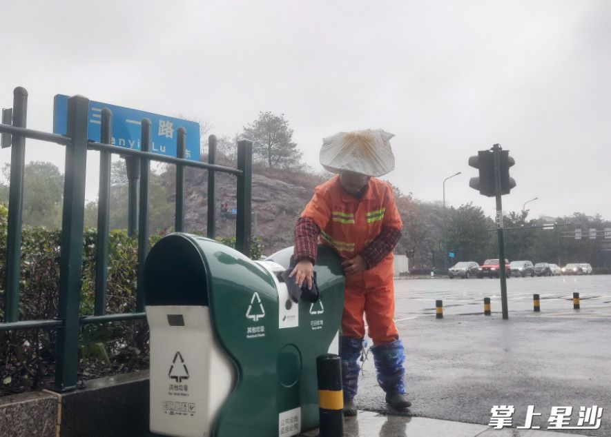 杨春香在认真擦拭街边垃圾桶。
