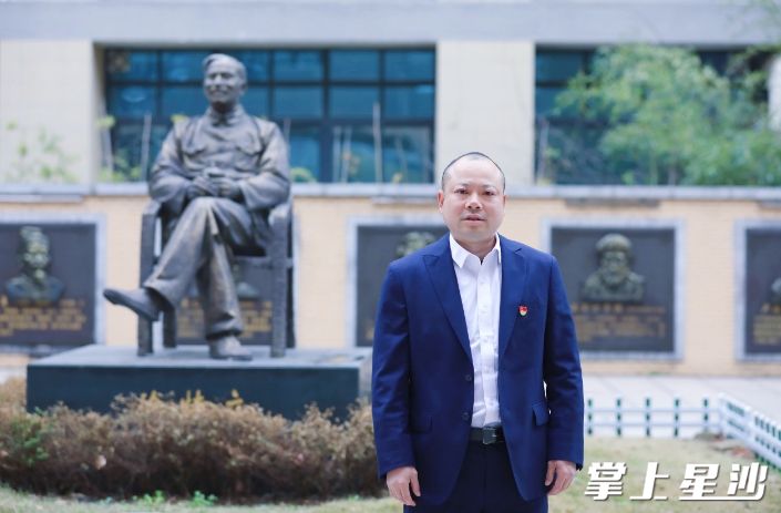 刘志慧在学校徐特立铜像面前留影。