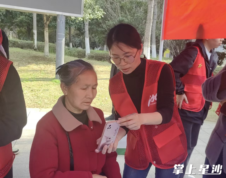 志愿者教居民用手机进行养老认证。万景社区供图