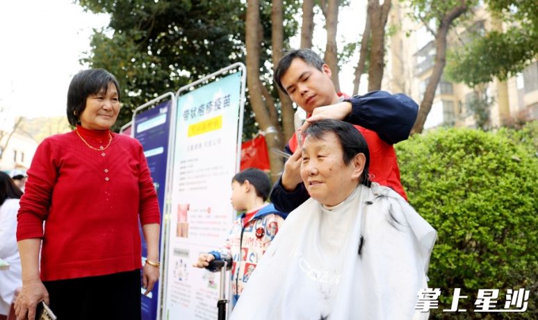 图为刘辉在社区便民服务活动现场为居民免费理发。均为盛磊 摄