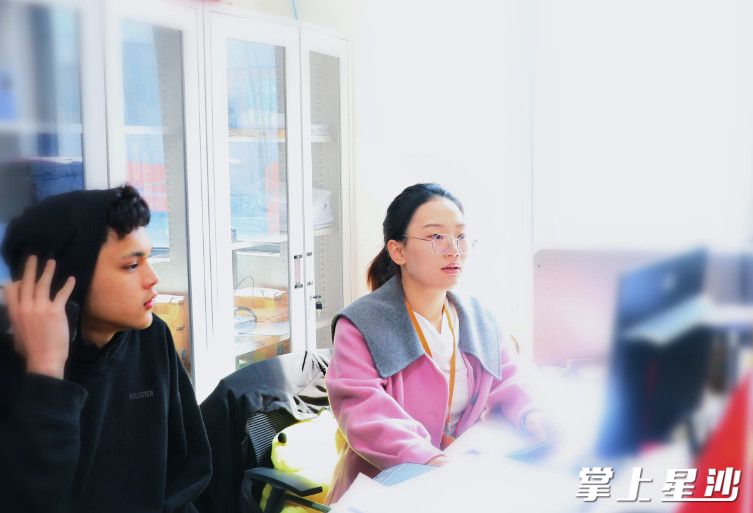 在长龙街道金牌"店小二"指导下,学校老师帮助马来西亚学生李杰城(中文