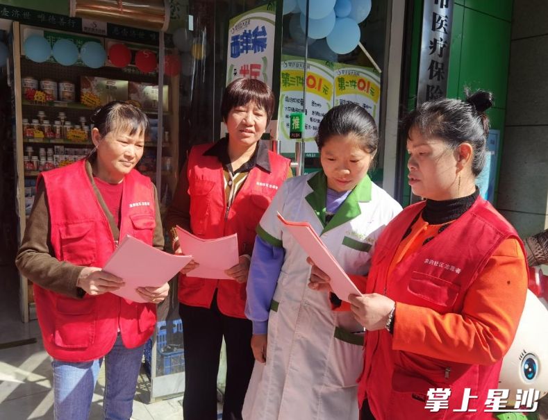 海德公元小区巾帼志愿者向门店经营户发放消防安全宣传资料。