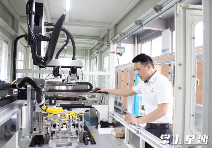 LTCC生瓷片自动化生产线正在高效运作，工作人员在一旁查看。均为宋彬彬 摄
