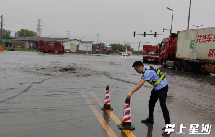 城管队员在积水路段设置路障。均为黄兴镇供图