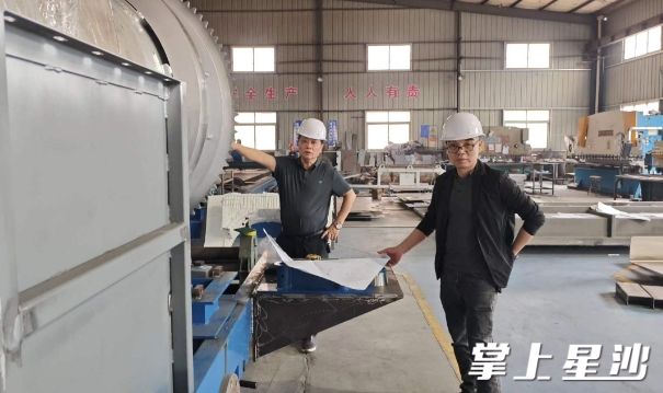 姜国明（左）和文小洪（右）在车间检查调度生产情况。企业供图