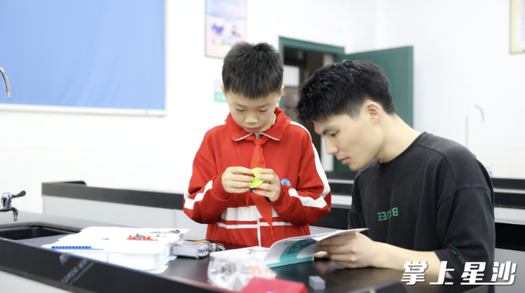 图为马浩航在指导老师帮助下进行科学实验。盛磊 摄