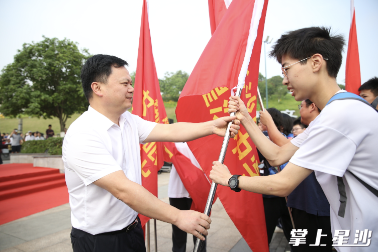 长沙县教育局党委书记、局长李文杰为环湖毅行的学校授旗。