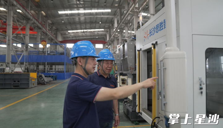 图为陈留洋与父亲陈建波在车间内查看设备运转情况。艾哲文 摄