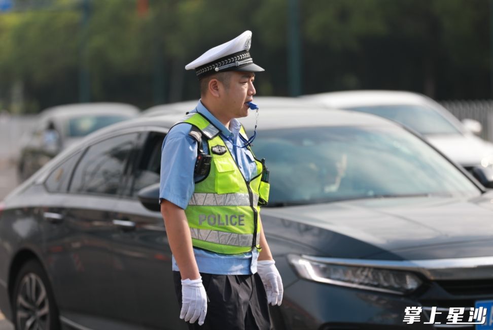 长沙县一中考点门口附近，交警正维持交通秩序。李杰 摄