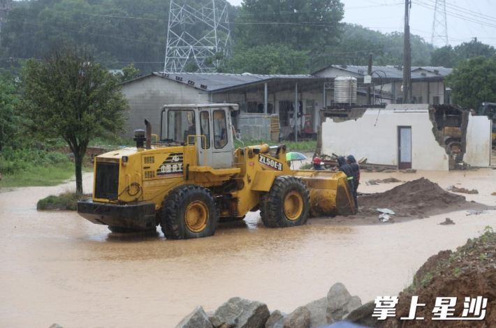 黄兴镇派出铲土机对堤坝进行加固。陈晨 摄