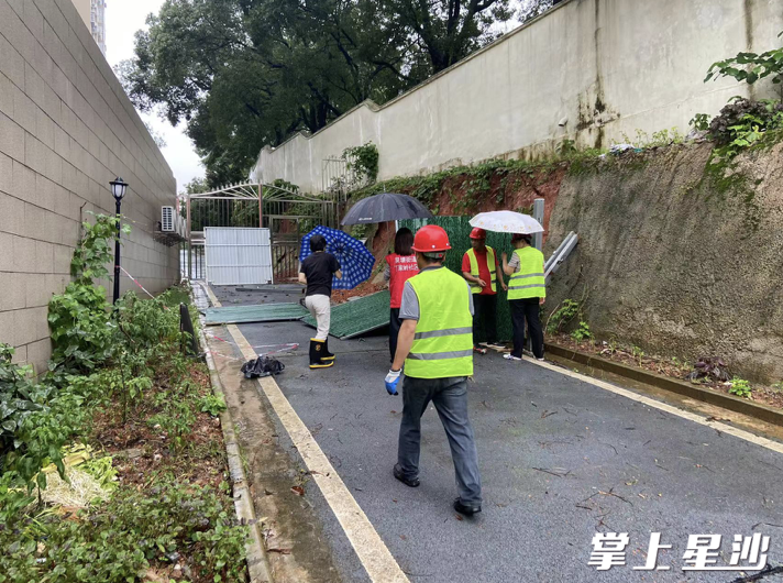 豪都新天地小区，物业工作人员对围墙设置安全防护措施。