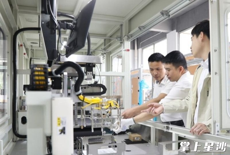 建宇网印生产车间内，技术人员探讨研发创新。杨源 摄