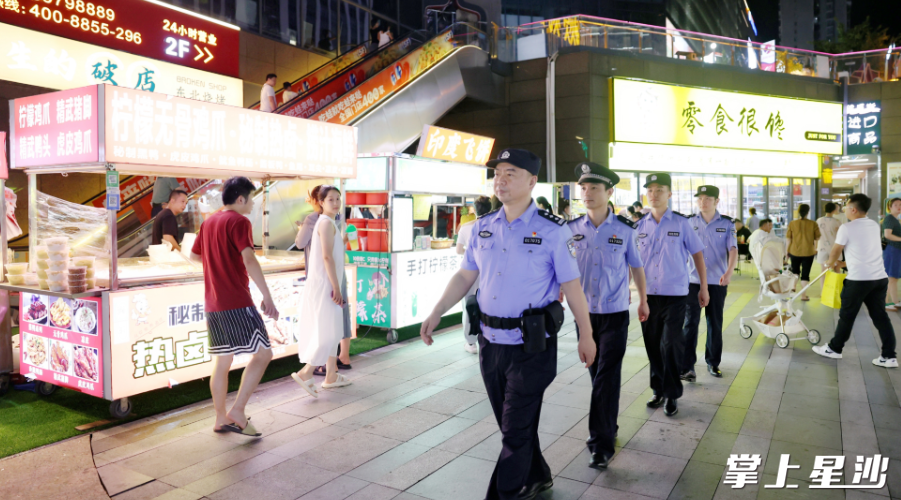 新安派出所民警在辖区中茂城星光夜市开展治安巡逻。