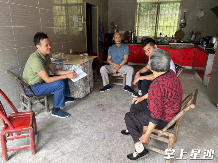 黄文思（左二）与陈红献（左一）正在村民家中走访。