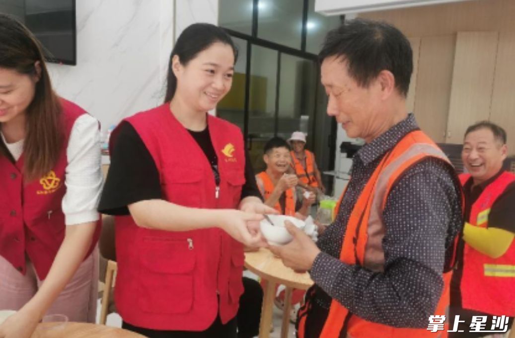 社区星锋党员志愿者一一为环卫工人端上精心熬制的绿豆粥。社区供图